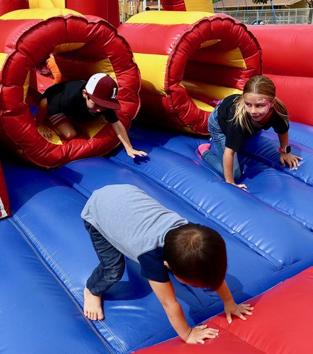 Excited youngsters make their way through a bounce house at the annual MIQ Fall Festival.